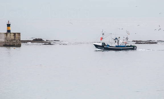Barco de pesca y faro en Comillas